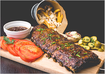 Ribs, veggies, and fries sit on a cutting board